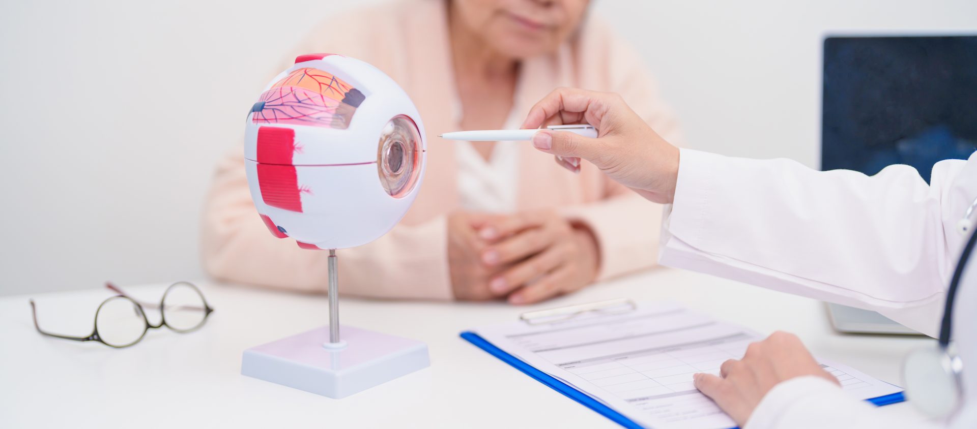 Elderly Patient consulting Doctor to Eye disease, Senior Medical Diagnosis. Anatomy Eye model for Cataract, Glaucoma, Age Related Macular Degeneration, Diabetic Retinopathy, Vitreous, health concept