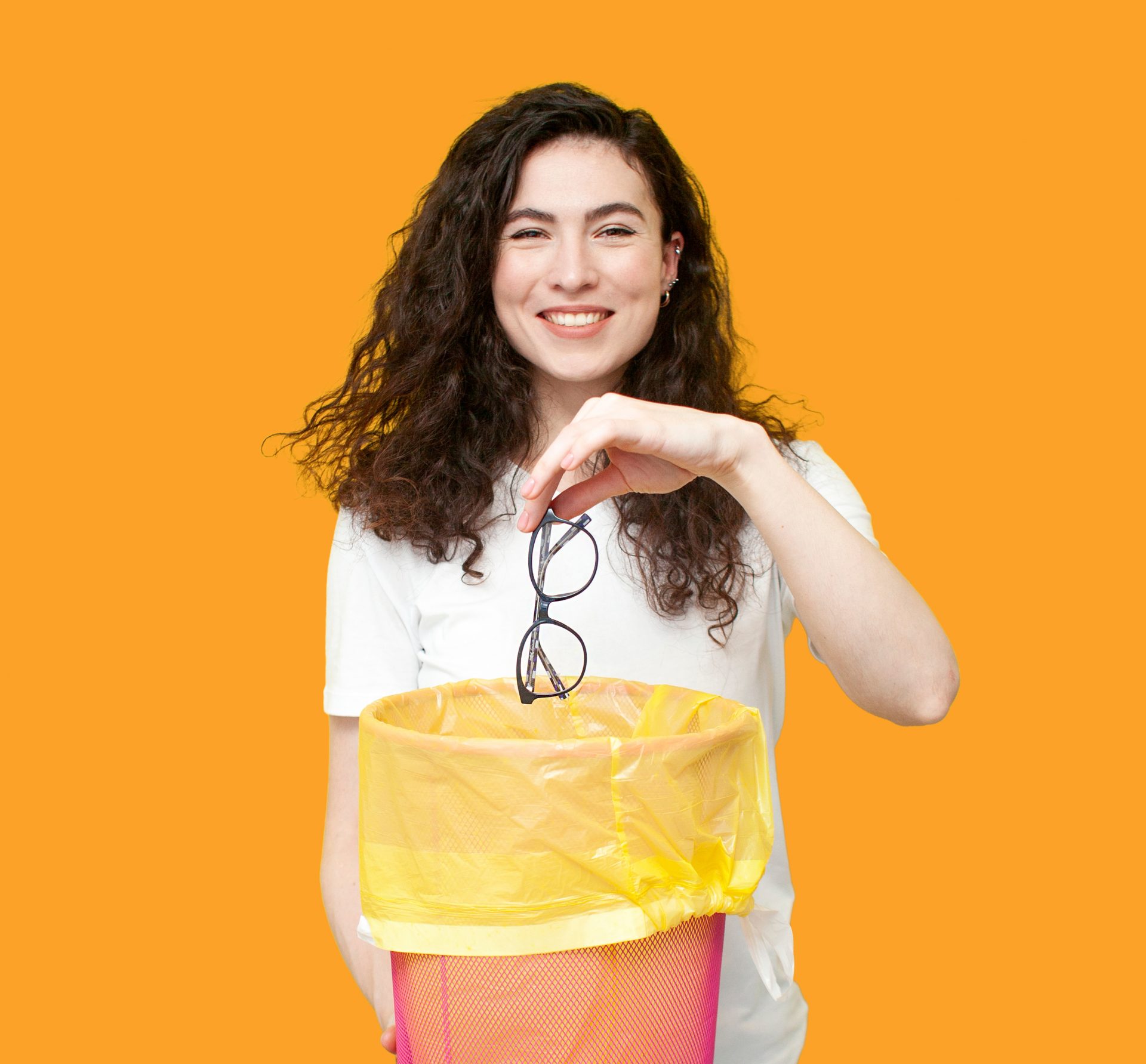 young cheerful girl throws glasses into trash can, the concept of treatment and vision correction
